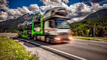 Truck carrying cars down highway