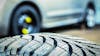Close up on tire with car in background