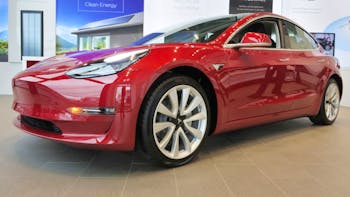 Red Tesla Model 3 inside the car shop