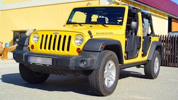 Yellow Jeep Wrangler parked in an open space