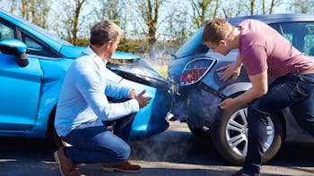 Drivers inspecting the cars damage