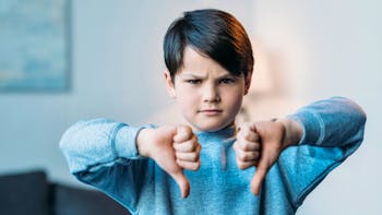 Boy showing thumbs down