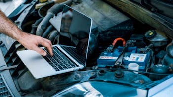 Cropped view of car mechanic using laptop with blank screen